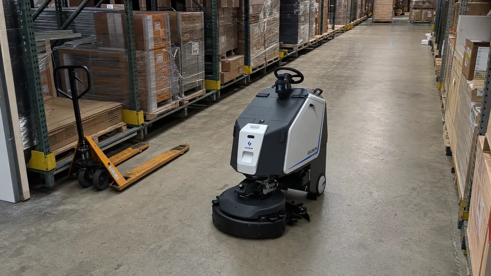 A Gausium Scrubber 75 commercial cleaning robot scrubbing a warehouse floor